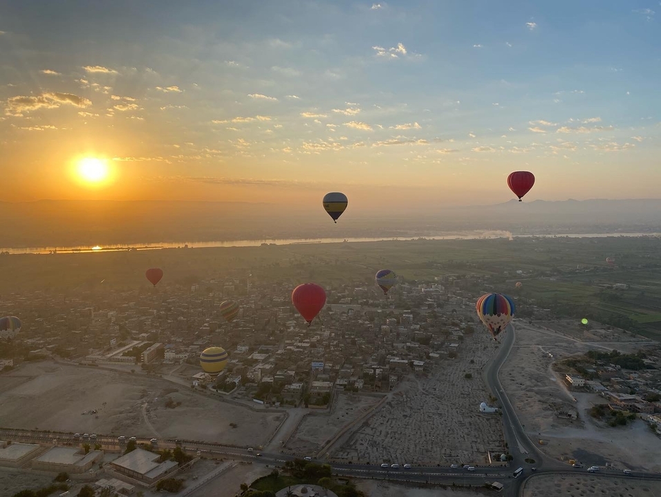 Montgolfières au-dessus du paysage urbain au lever du soleil.
