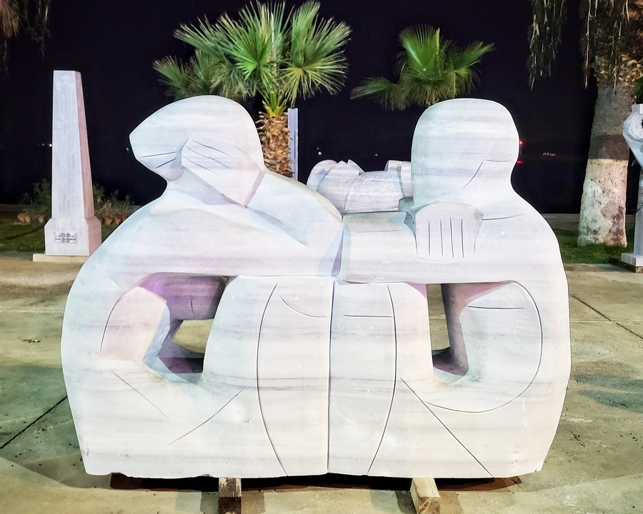 Sculpture dans un espace public la nuit.