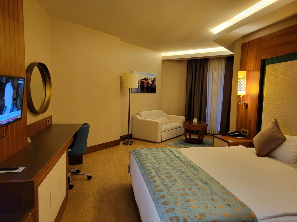 Chambre d'hôtel moderne avec un grand lit et un canapé.