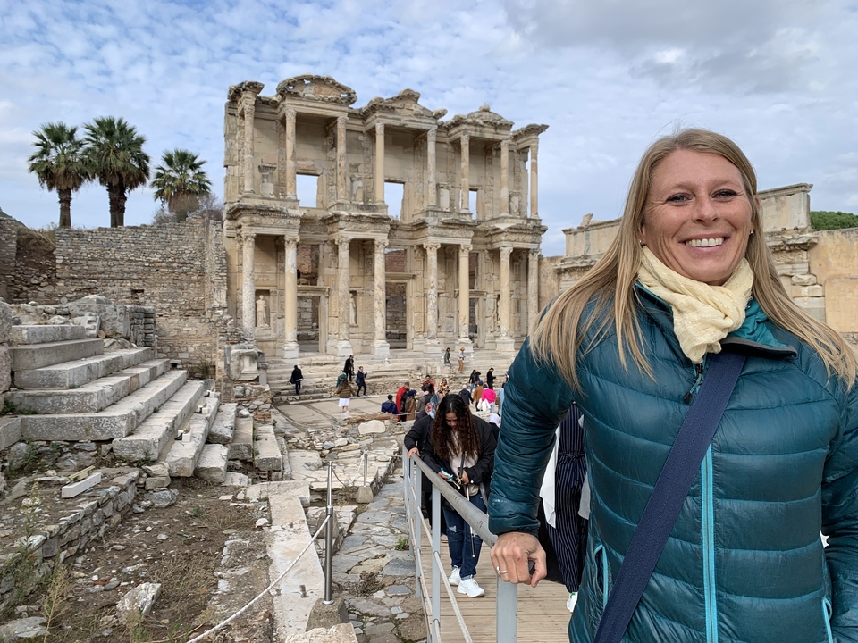 Des touristes sur un site de ruines antiques avec de grandes colonnes.