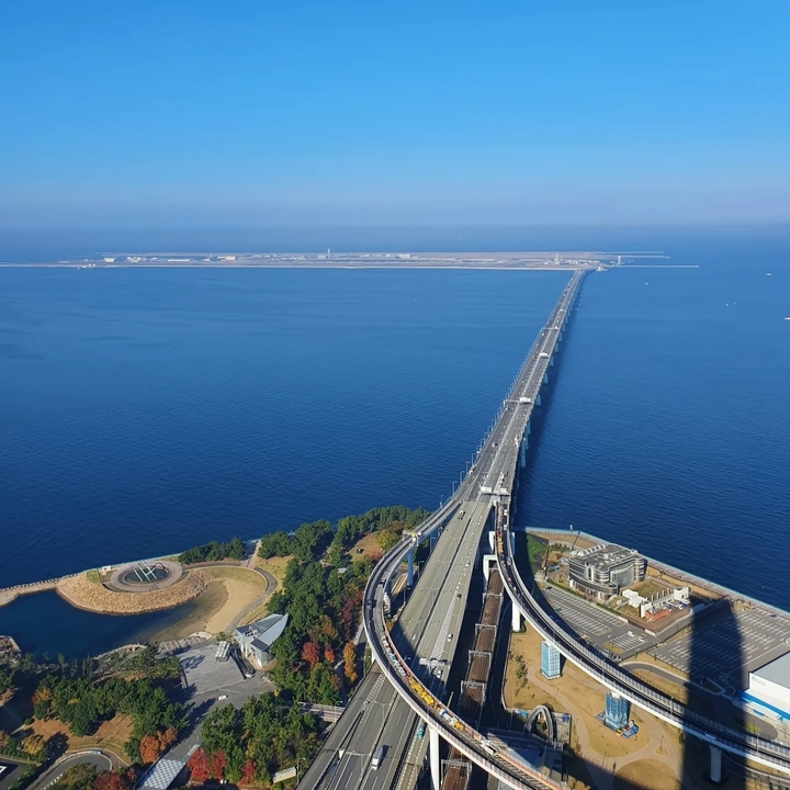 Pont long s'étendant au-dessus de l'eau avec une vue lointaine d'une île.