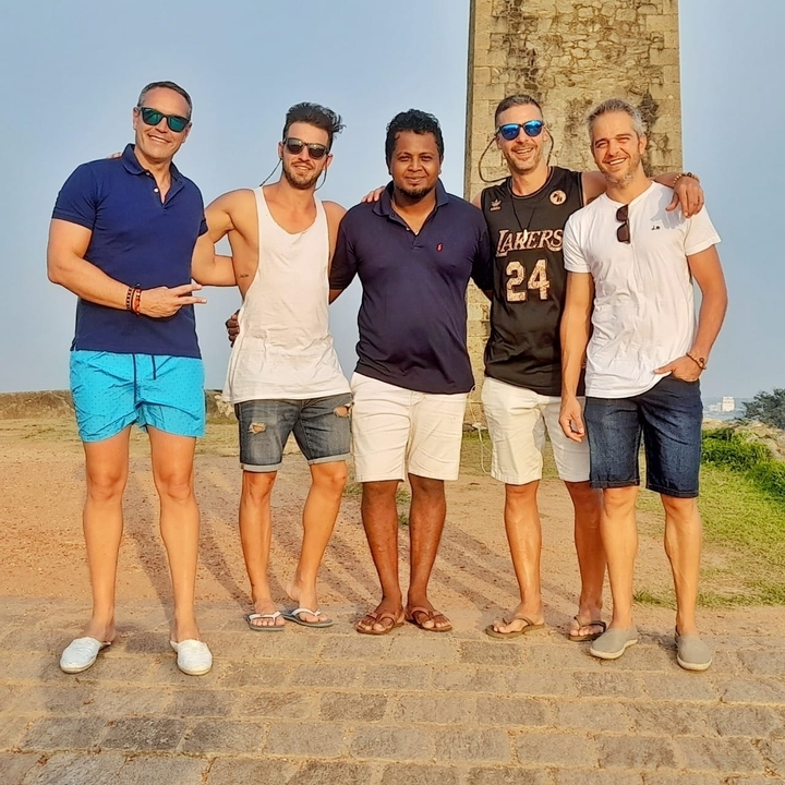 Groupe de cinq personnes posant ensemble à l'extérieur.