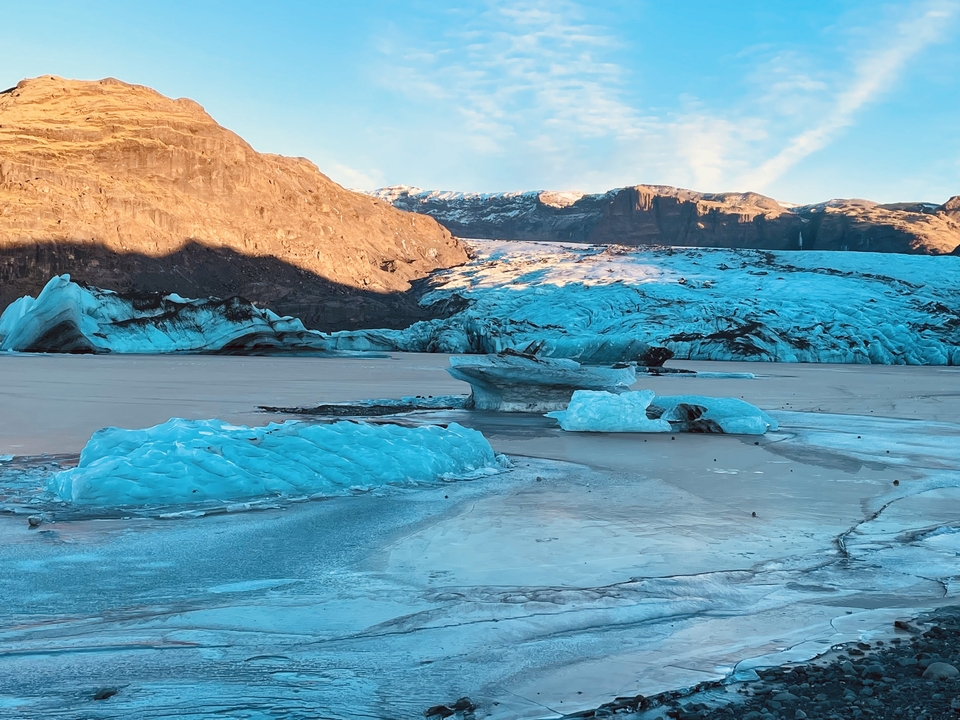 Icebergs and mountains in a glacial lagoon setting.