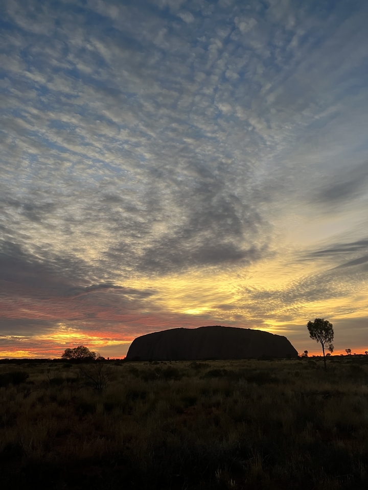 Formation rocheuse en silhouette contre un ciel illuminé.
