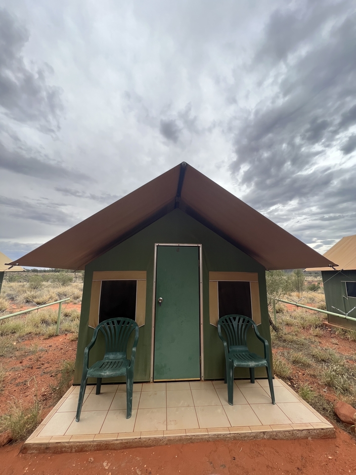 Campement de tentes installé sous un ciel nuageux.