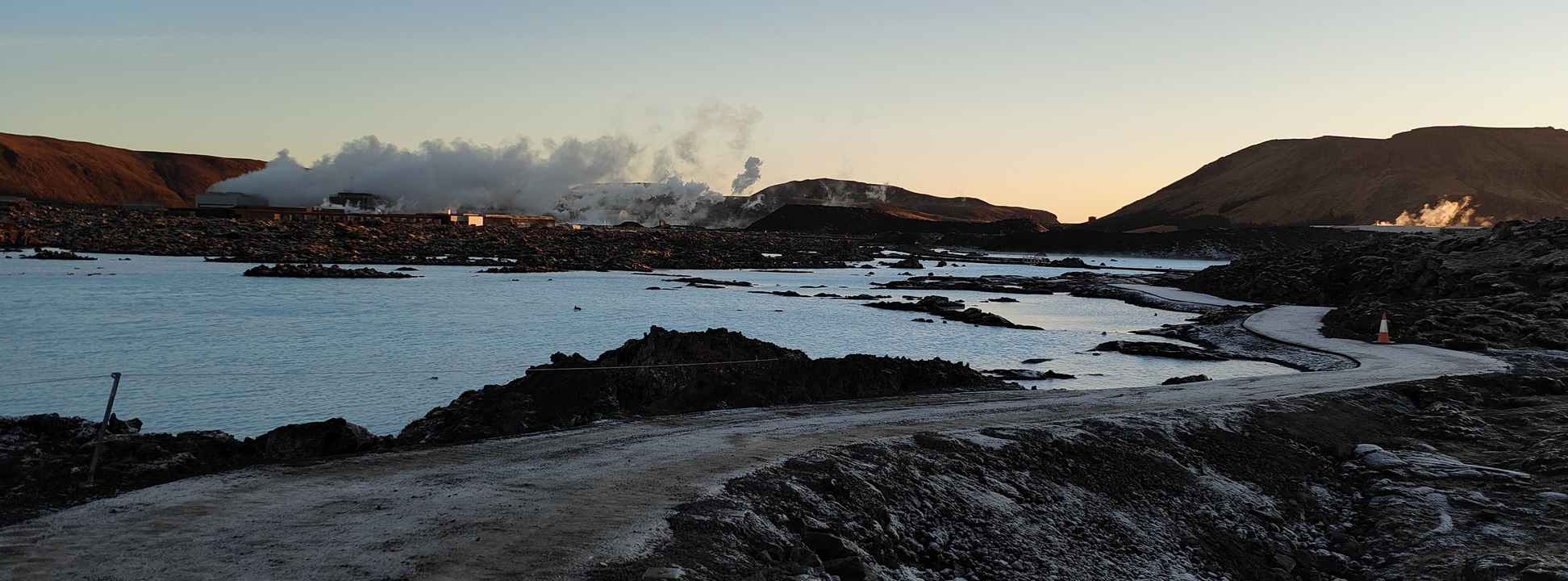 Icelandic hot springs with steam rising during sunset.