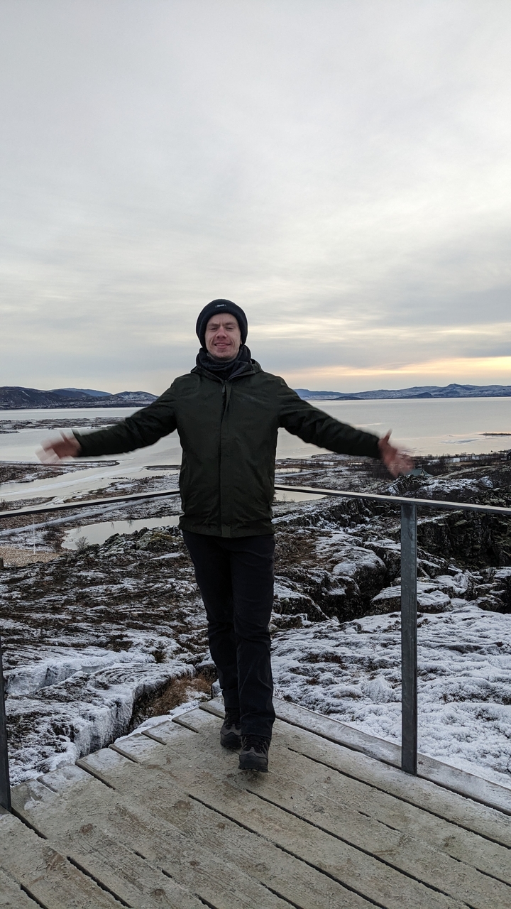Person with arms outstretched on a scenic overlook.