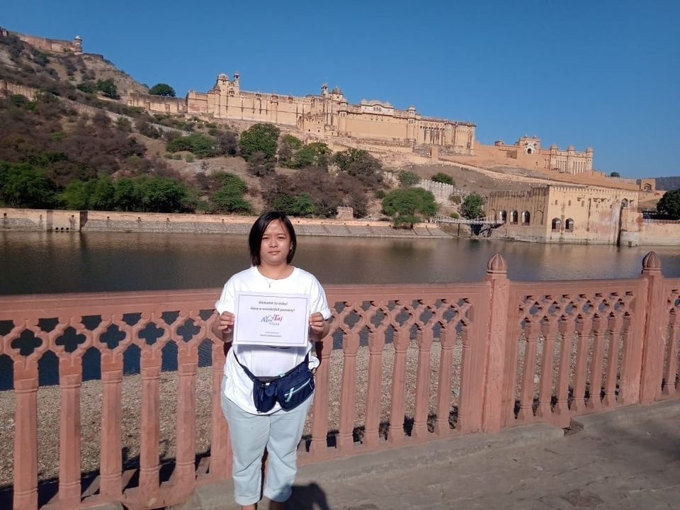 Personne tenant un certificat devant le fort d'Amber.