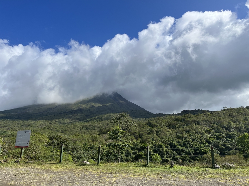 Vue du volcan Arenal partiellement couvert de nuages.