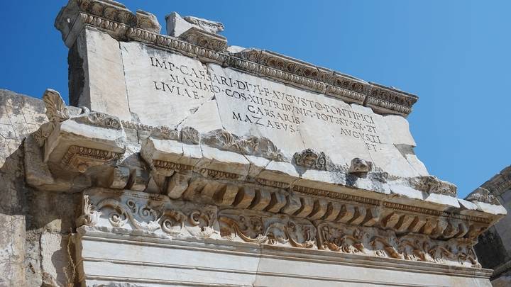 Ancient Roman stone inscription with clear blue sky.