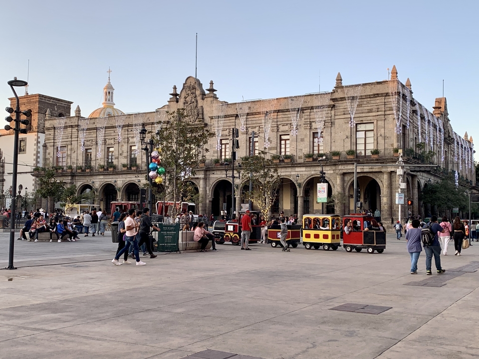 Place avec bâtiment historique et un petit train.