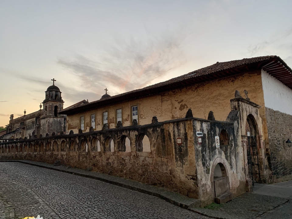 Ancien bâtiment en pierre avec détails de croix et d'arches.