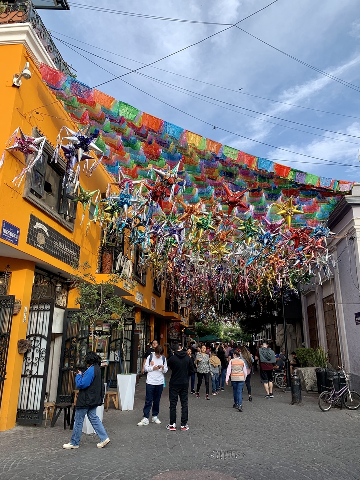 Rue avec des décorations vibrantes et des bannières colorées.