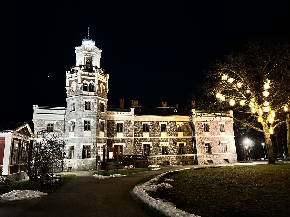 Bâtiment historique illuminé la nuit avec des lumières sur un arbre.