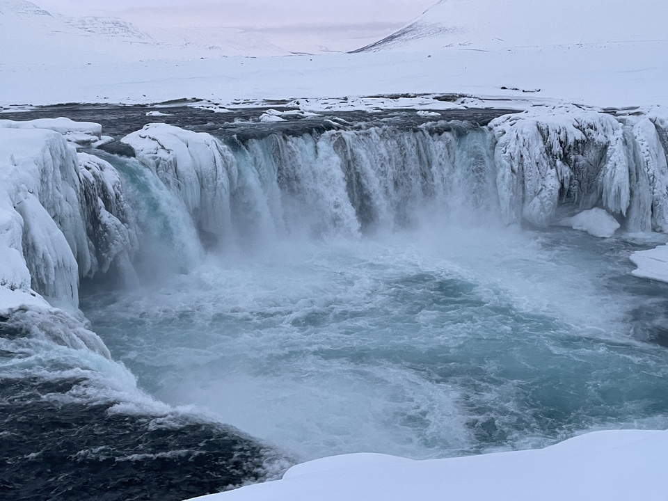 Frozen waterfall in a snow-covered area.