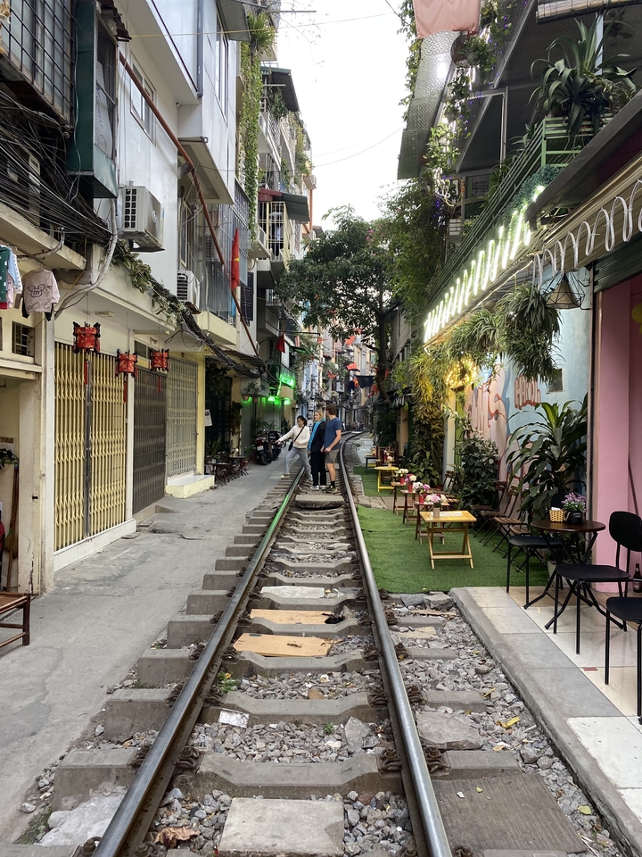 Personne se promenant le long d'une voie ferrée dans une zone urbaine.