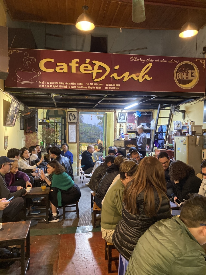 Café avec des gens qui savourent des boissons et des conversations à l'intérieur.