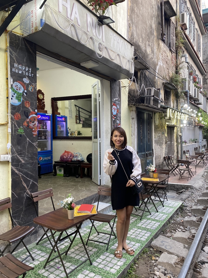 Femme debout devant un magasin avec une façade lumineuse et colorée.