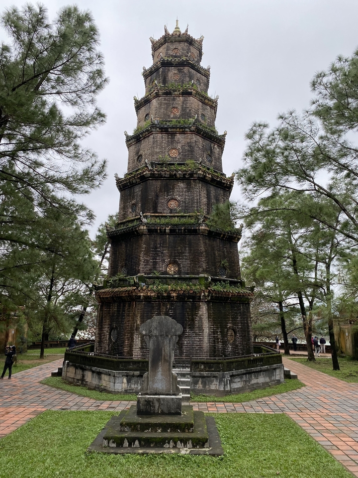 Tour en brique historique entourée d'arbres dans un cadre de parc.