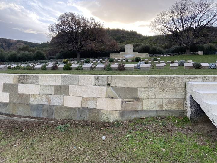Pierres tombales soigneusement alignées dans un cimetière bien entretenu.
