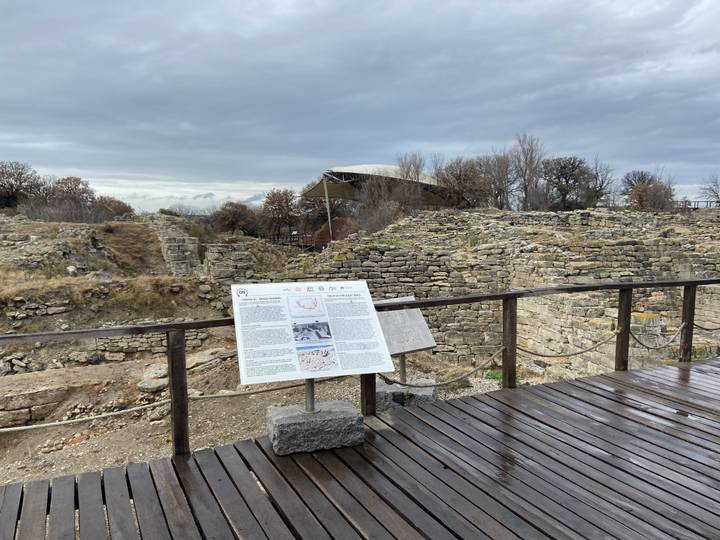 Ruines archéologiques avec panneau d'information.