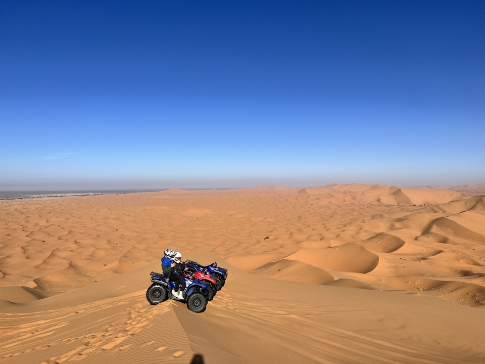 Deux personnes sur des quads dans un vaste paysage désertique