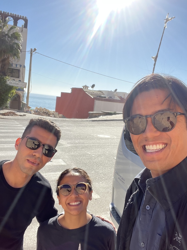 Trois personnes posant avec une vue sur la mer et les bâtiments