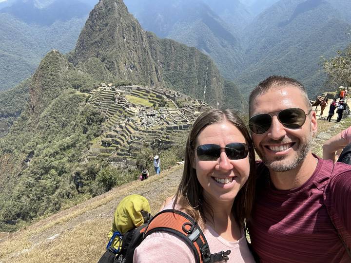 Two people smiling with Machu Picchu in the background.