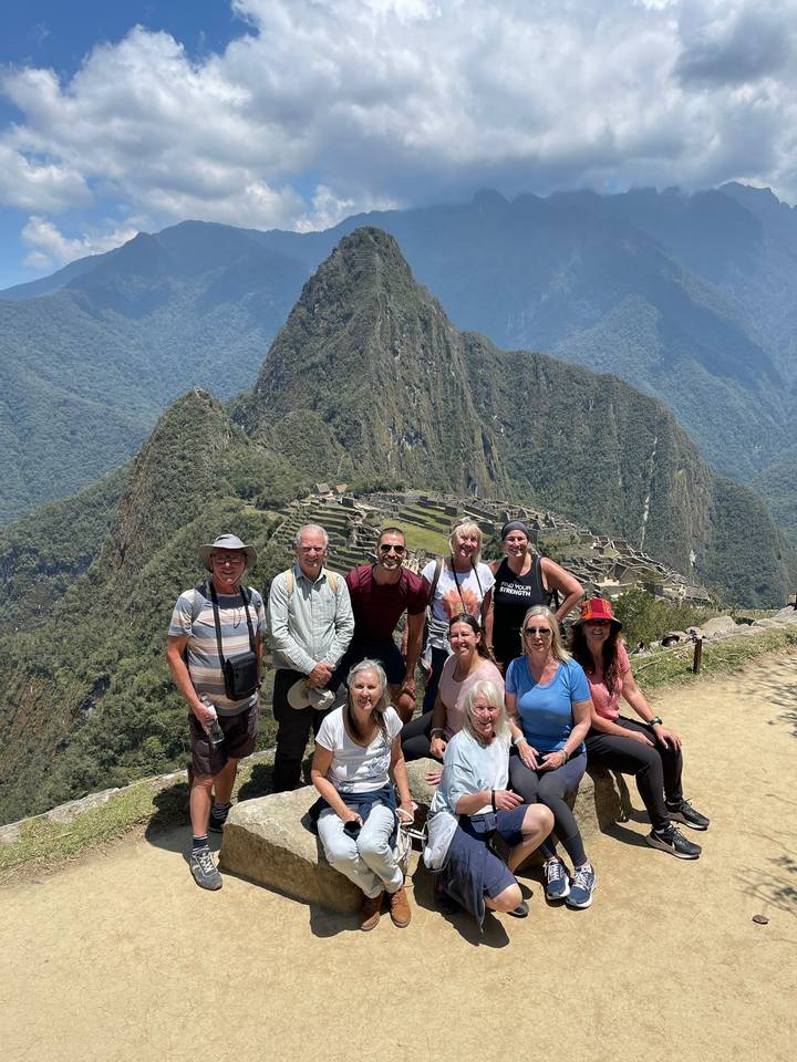 Group of people posing with a mountain backdrop.