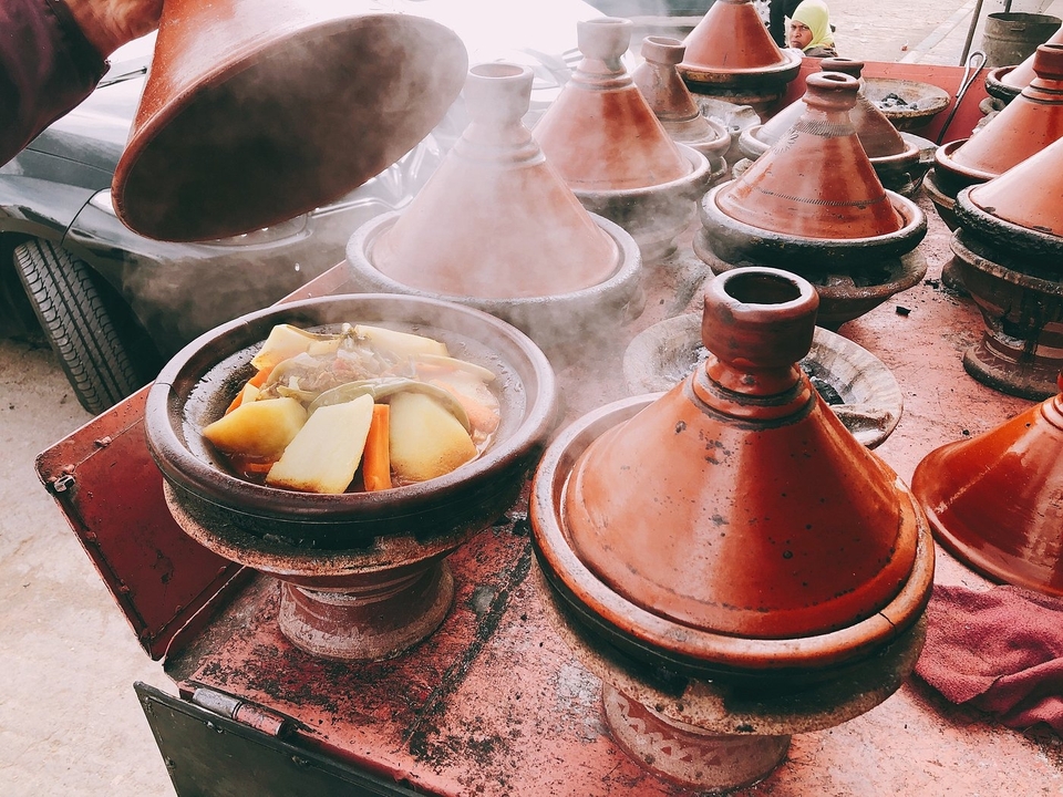 Eine Vielfalt dampfend heißer Tajine-Gerichte mit Gemüse.