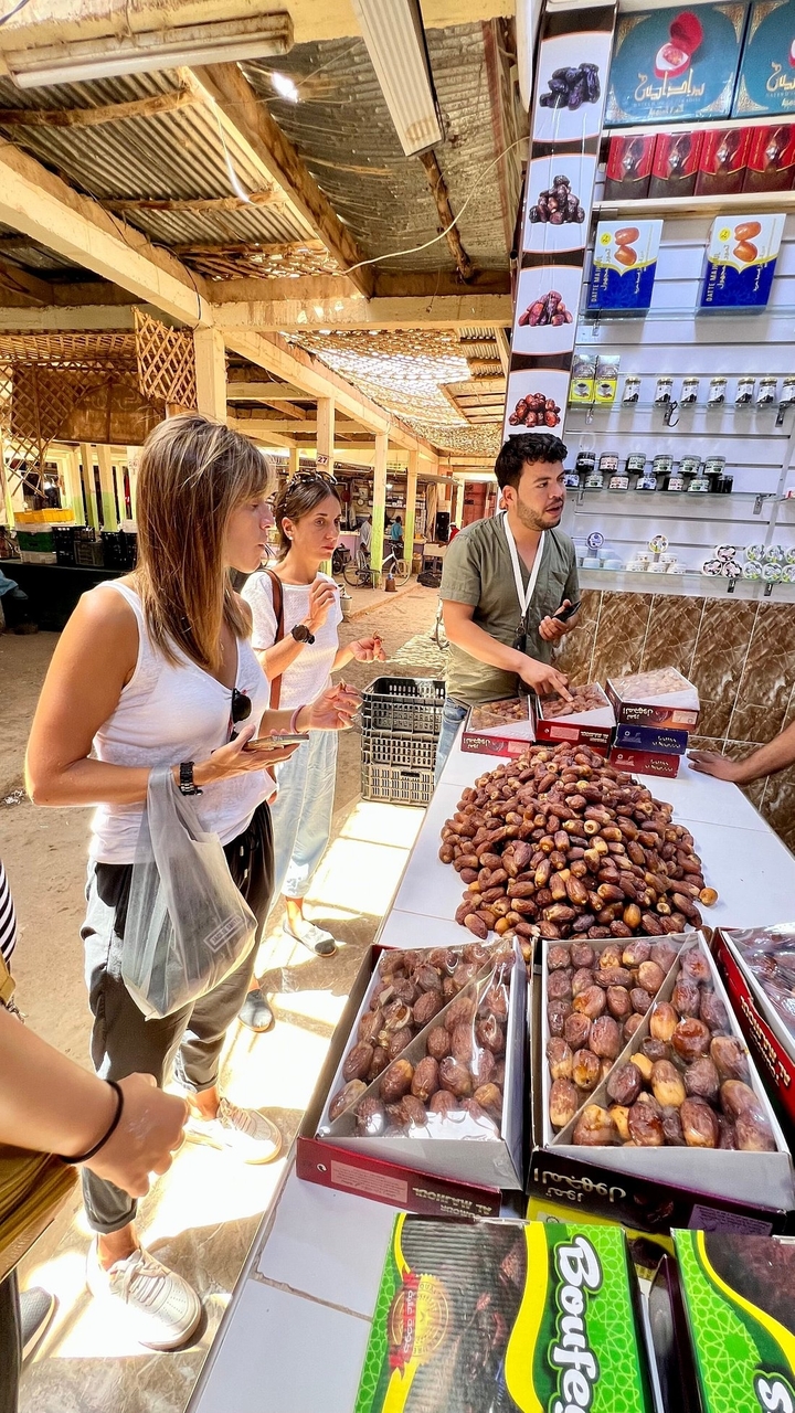Menschen probieren Datteln auf einem Obstmarkt.