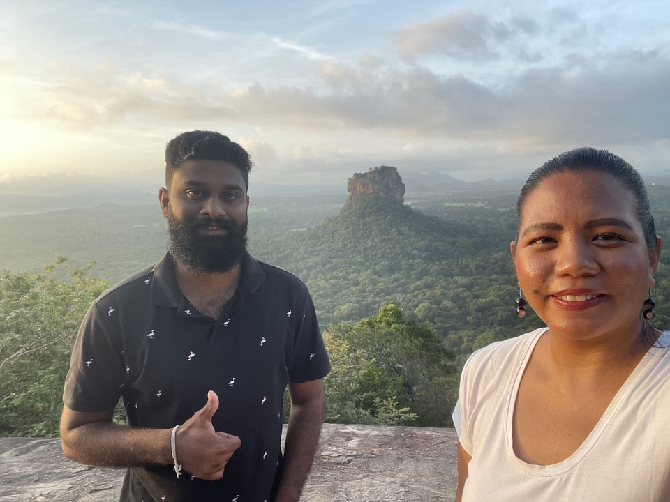 Deux personnes posent avec le rocher de Sigiriya en arrière-plan.