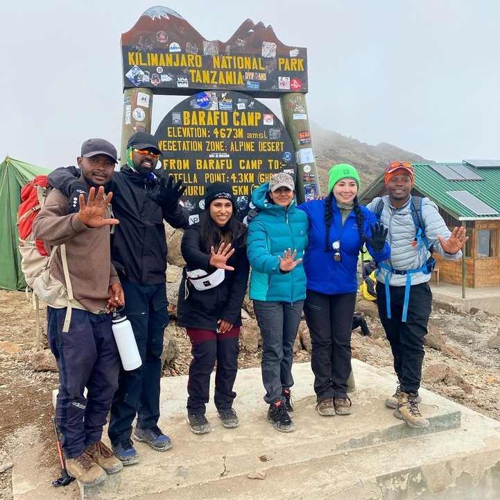 Groupe de personnes posant devant le panneau du camp de Barafu.