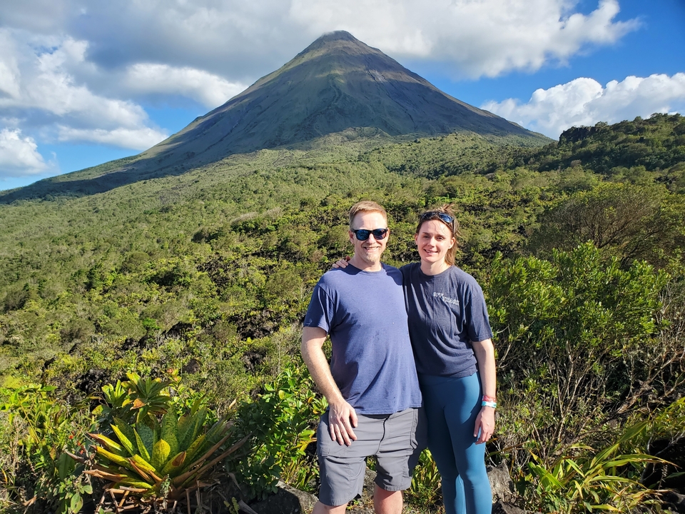 Couple posant avec un volcan en arrière-plan.
