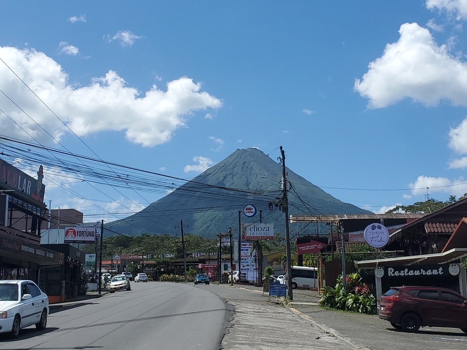 Volcan s'élevant au-dessus d'une ville sous un ciel bleu dégagé.