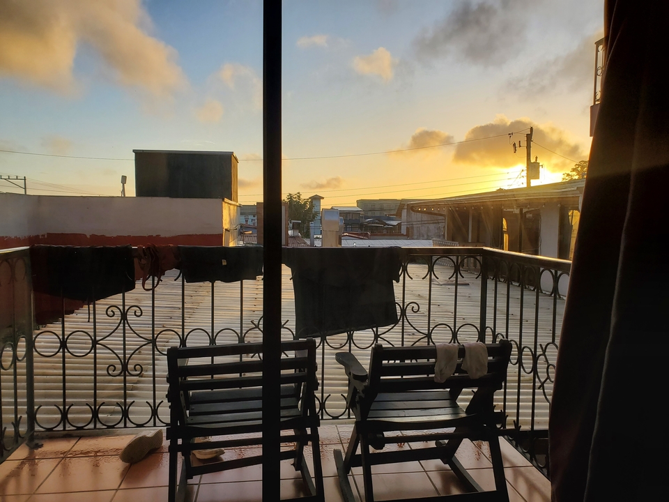 Vue du balcon avec coucher de soleil et linge suspendu.