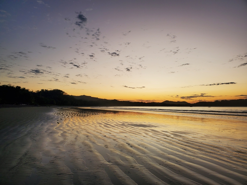 Plage au coucher du soleil avec de magnifiques reflets dans le sable mouillé.