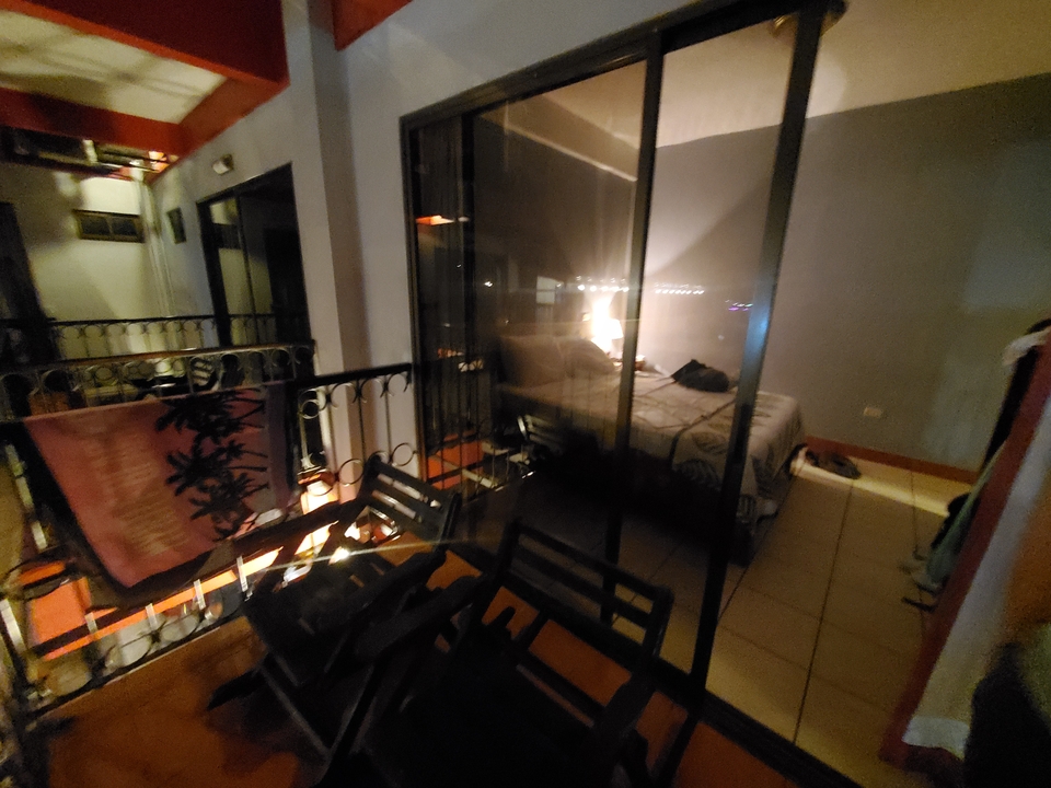 Vue floue d'une chambre d'hôtel à travers une cloison vitrée.