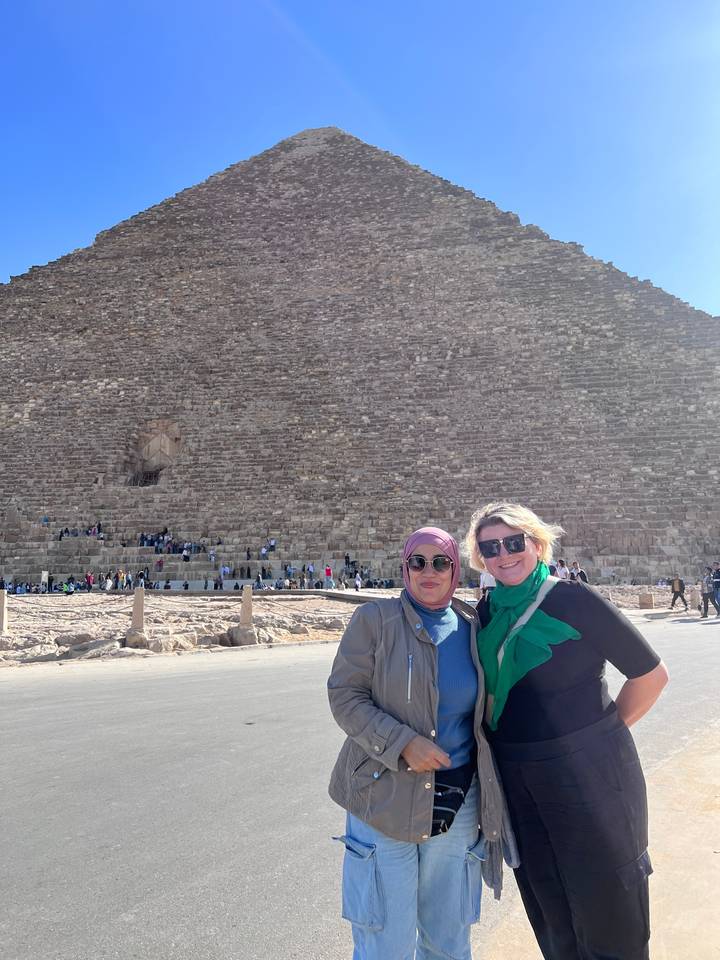 Deux personnes posant devant une grande pyramide.