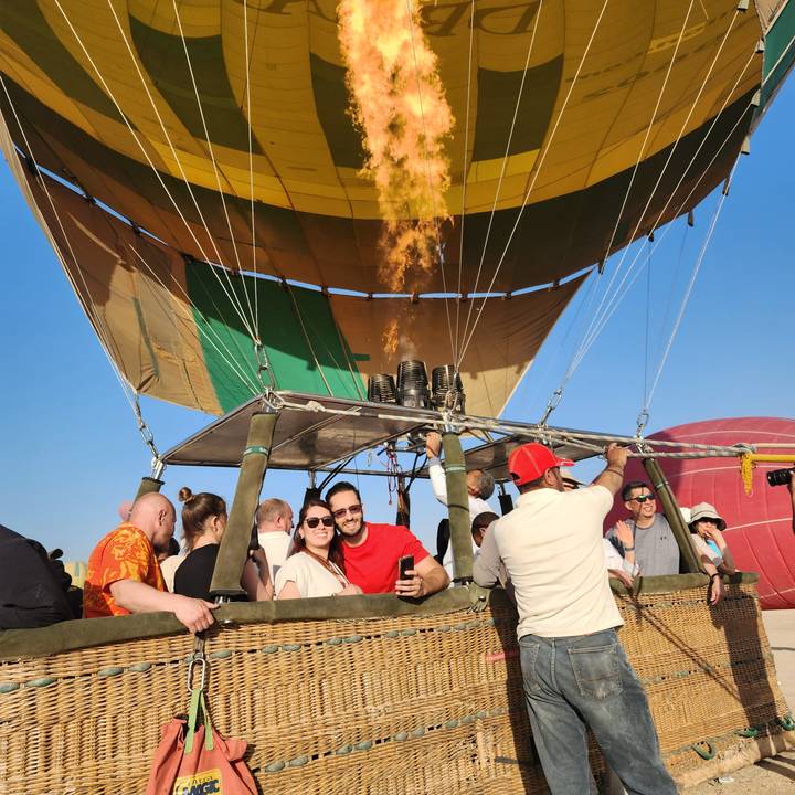 Montgolfière avec des flammes et des personnes dans la nacelle.