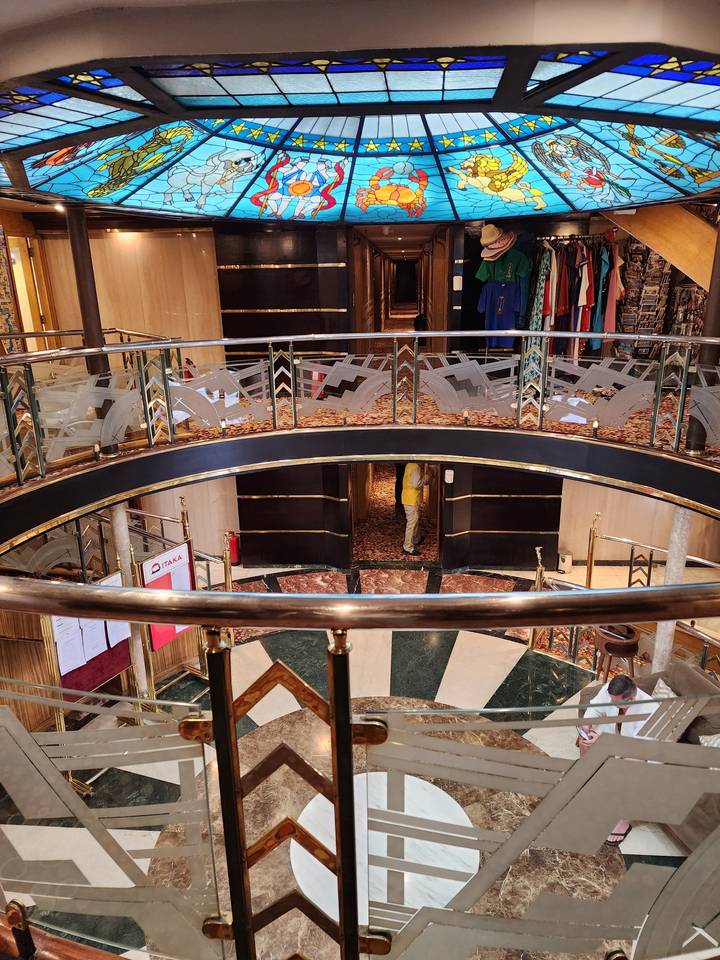 Vue intérieure d'un grand escalier et d'un plafond en vitrail.