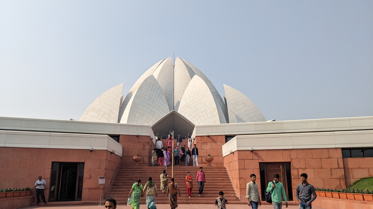 Le Temple du Lotus avec des visiteurs montant les marches sous un ciel dégagé.