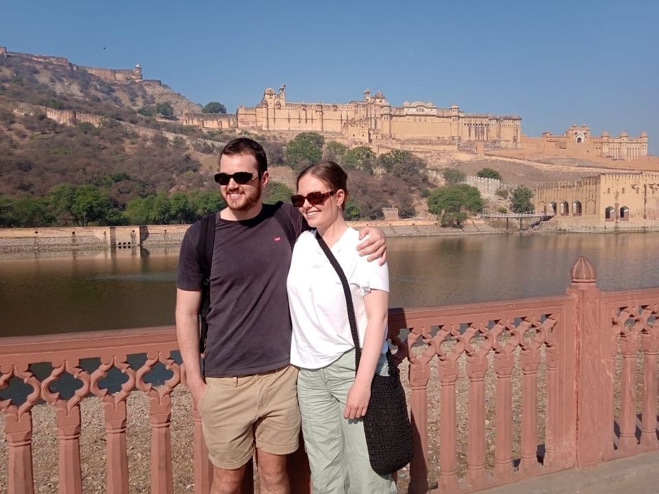 Couple posant avec un fort historique en arrière-plan.