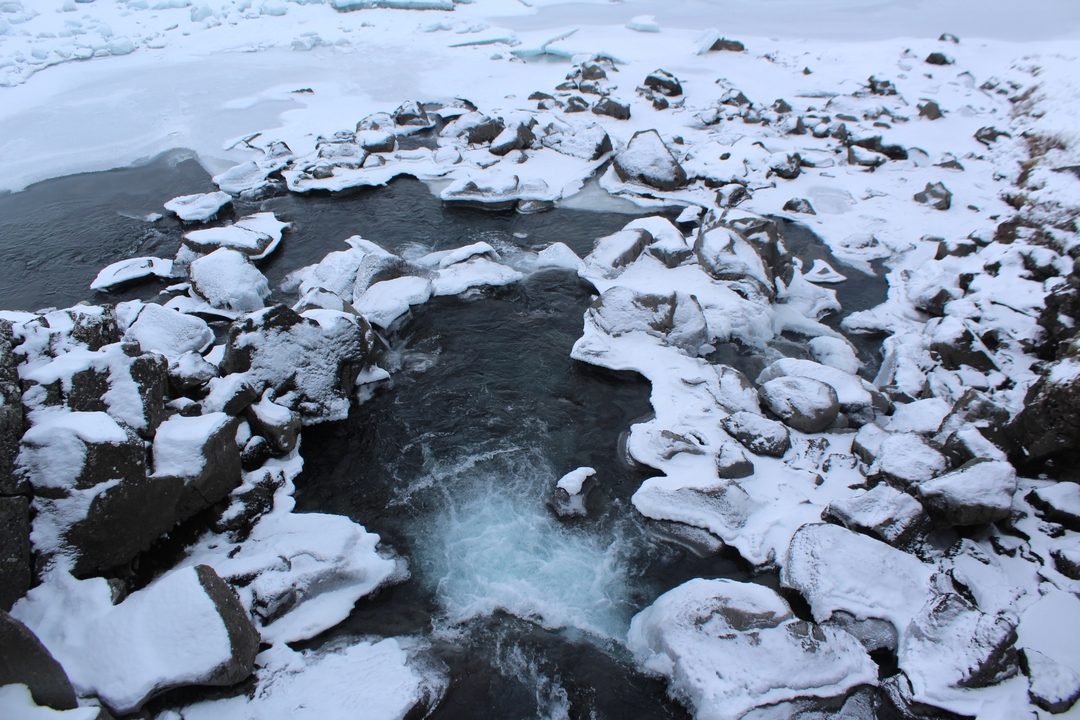 Rivière glacée avec des rochers couverts de neige