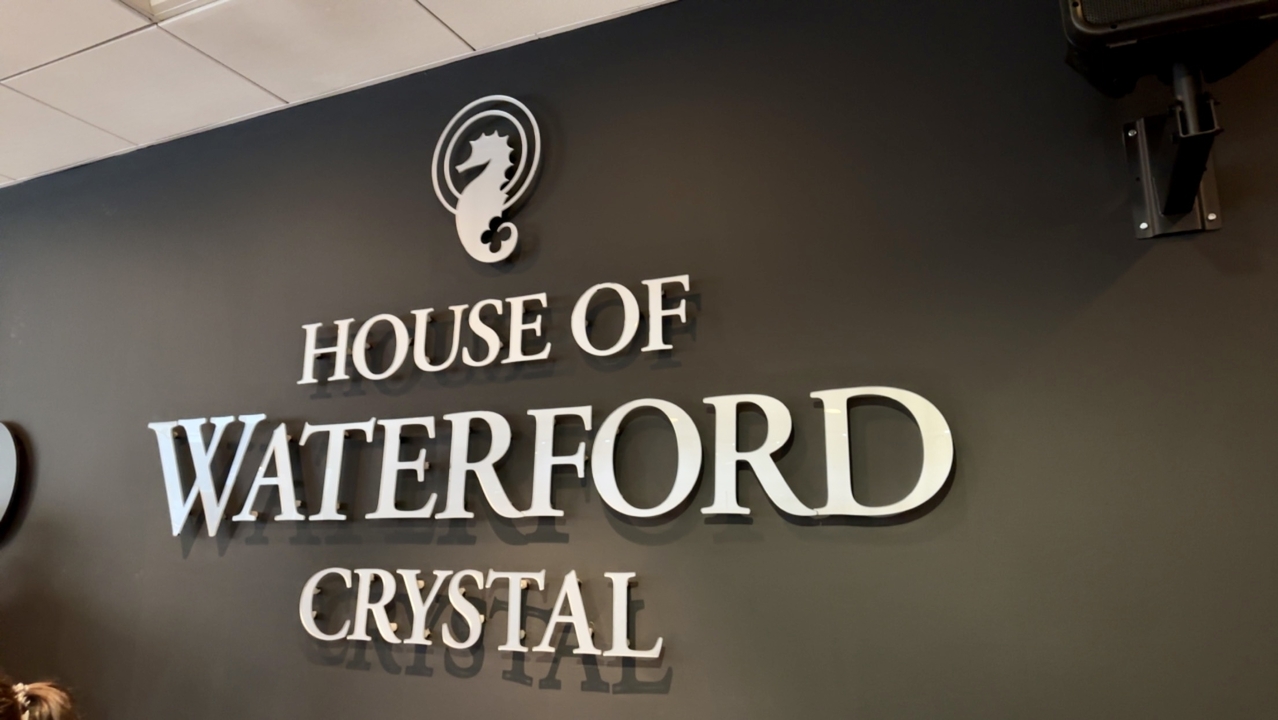 Panneau de la Maison de Cristal de Waterford sur un mur noir.