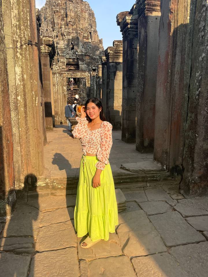 Woman smiling in front of ancient temple ruins