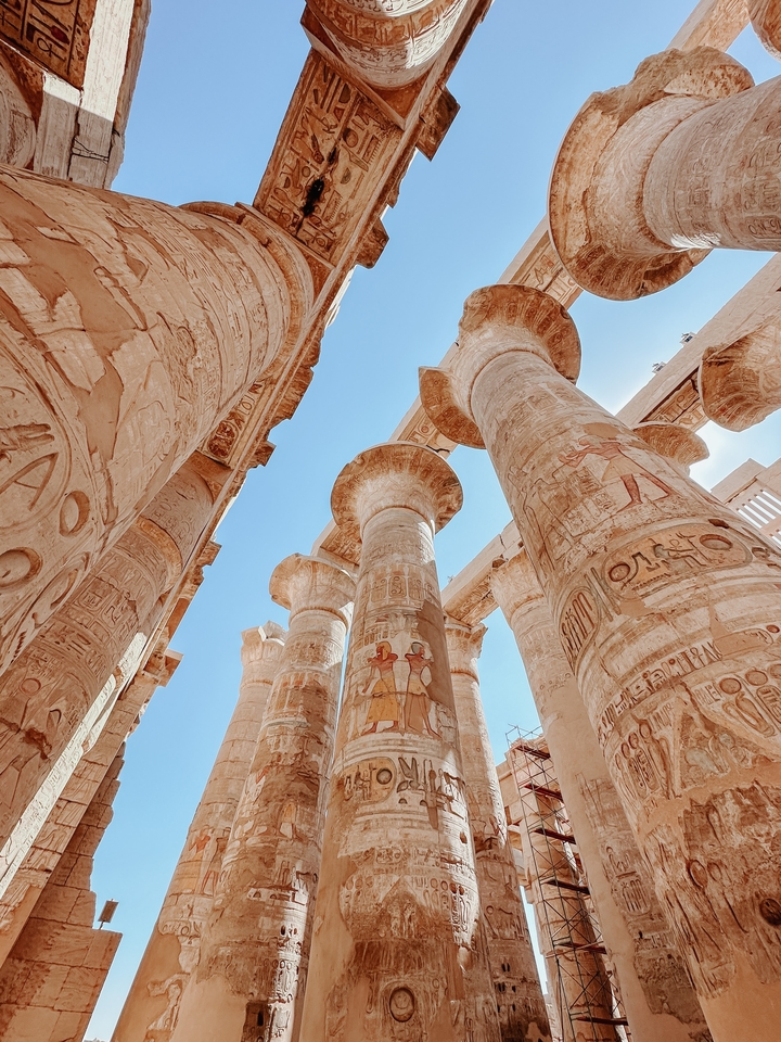 Colonnes antiques avec hiéroglyphes se détachant sur un ciel bleu.