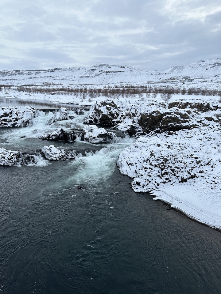 Cascades coulant sur un terrain rocheux couvert de neige.