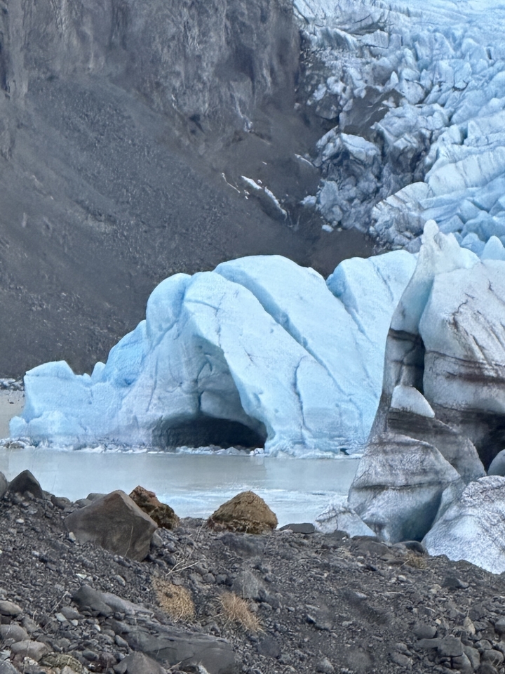 D'immenses formations glaciaires bleues entourées d'un terrain rocheux.
