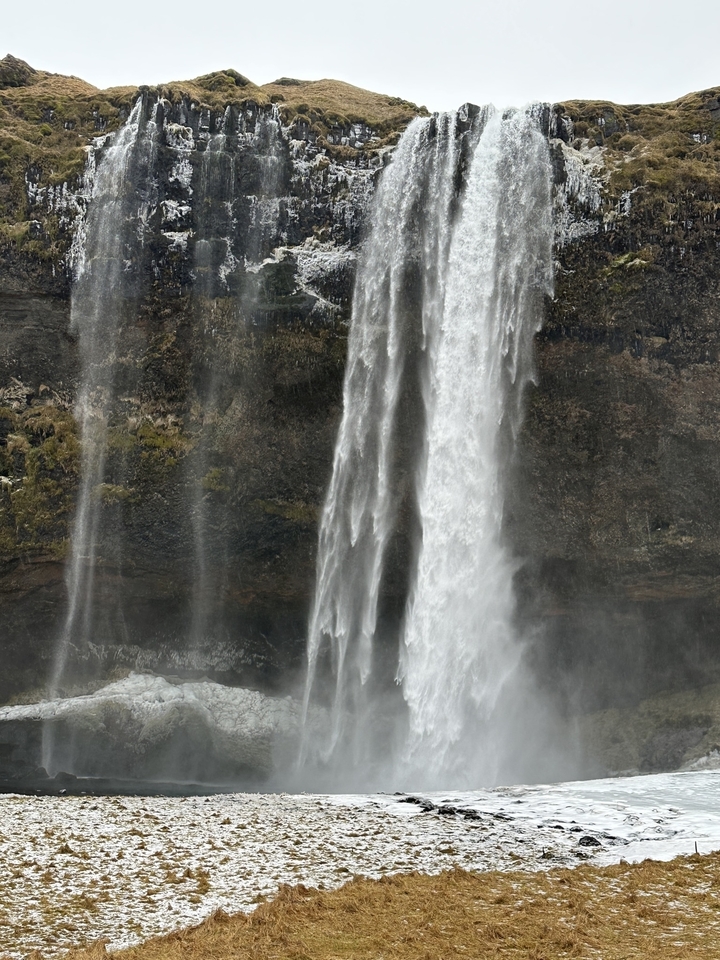 Une haute cascade qui dévale une falaise rocheuse.